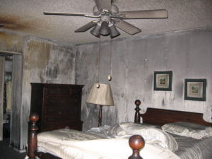 Smoke damage of a master bedroom where walls, and ceiling have the most visible smoke damage.